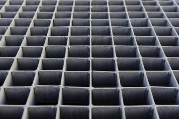 The gray metal grating on the street drain.