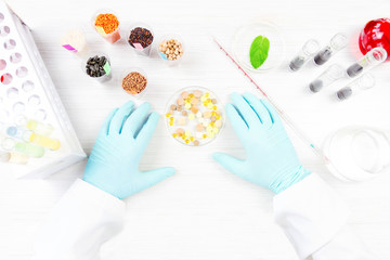 Scientist testing gmo plants and seeds in biological laboratory. Top view 