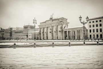 illuminated Brandenburg gate (Brandenburger Tor) and 18th of March Square in snow, Berlin, Germany, Europe, Vintage sepia style