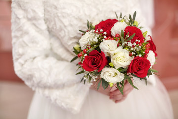 Bride in white dress holding wedding bouquet in hands