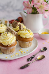 Yellow cupcakes spring in style on a pink background (close-up)