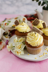 Cupcakes with yellow cream and spring flowers