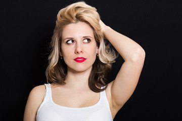 Obraz premium Woman with blonde curls and red lipstick on a dark background closeup