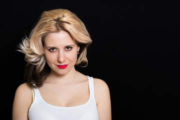 Naklejka premium Woman with blonde curls and red lipstick on a dark background closeup