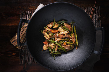 stir fried chicken in cast iron wok in flat lay composition - obrazy, fototapety, plakaty