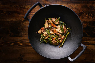 stir fried chicken in cast iron wok in flat lay composition