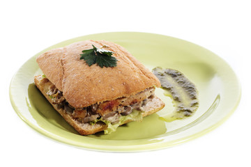 Healthy chicken and mushroom sandwich on green plate over white background