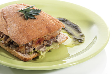 Healthy chicken and mushroom sandwich on green plate over white background