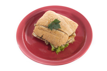 Healthy chicken and mushroom sandwich on red plate over white background