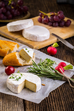 Cheese with white mold, radish, grapes and baguette with herbs