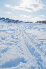 in winter the frozen river with traces trails bright day.