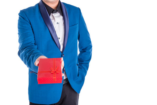 A man in suit giving red present box over white background
