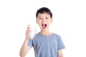 Young asian boy holding a glass of milk over white background