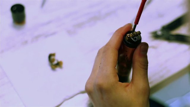 Male hands preload coils of the electronic cigarette. Vape after-sales service. Vaping. ENDS.