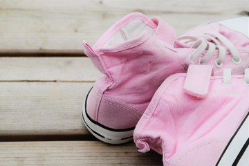 Pink sneakers for  summer, on a wooden surface