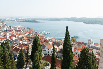 Fototapeta premium widok na piękne europejskie miasto Šibenik w Chorwacji, Adriatyk, domy z czerwonymi dachami, lato, statki, zwiedzanie miejskiego placu zabaw