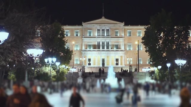 Greek parliament and Syntagma sq establish shot night slowmotion 100p.Dolly shot of the Greek parliament and Syntagma sq.People,traffic, and activity.No faces visible blur filter selectively applied.