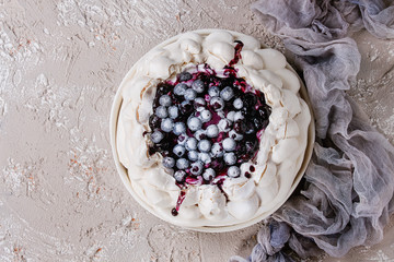 Homemade meringue cake Pavlova with whipped cream, sugar powder, fresh blueberries and blueberry...