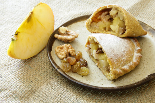 Russian pirozhki, baked patties or pies on basket with nuts and apples