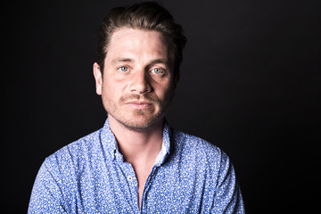 Closeup portrait of confident man on black background.