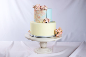 Artwork. Wedding cake decorated in pastel style with pink flowers