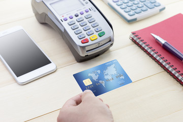 Cashier hand holding a Credit card over EDC machine or credit card terminal with calculator and...