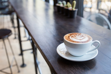 cup of coffee on wooden counter in cafe