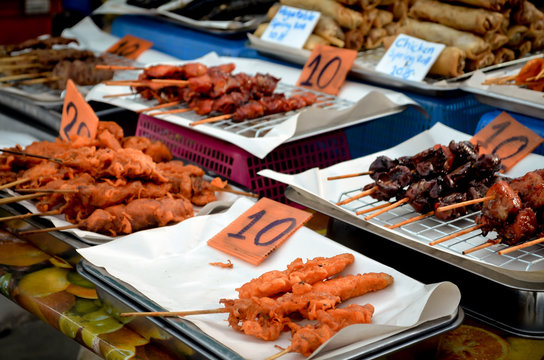 thai bbq chicken on sticks at street food market