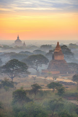 beautiful landscape view of sunrise and fog over ancient pagoda in Bagan , Myanmar