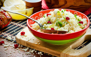 Couscous in oriental style with grains of pomegranate, lemon zest and butter