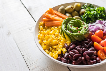 Vegan Buddha bowl. Mixed vegetable salad. Healthy meal concept. White wooden background.