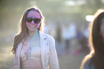 Portrait of a painted woman in the Holi festival of colors in sunlight.