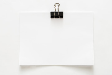 Blank paper sheet attached with clip isolated on white background © Prostock-studio