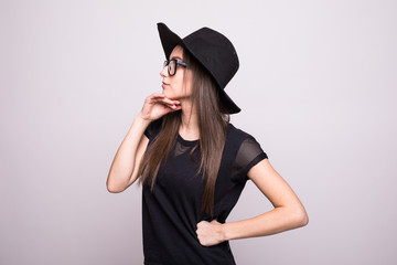 Young girl doing emotion. Dressed in a black shirt, black hat, glasses in studio