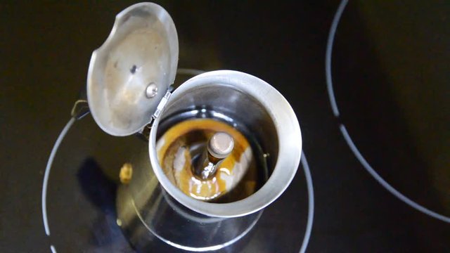 Coffee boils in the Italian coffee maker on induction cooker