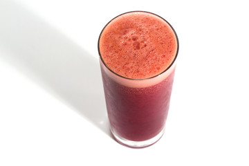 A glass of red healthy juice isolated over a white background