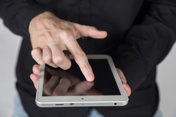 Young businessman holds and touch tablet pc