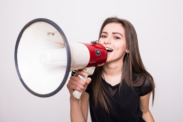 Pretty girl shouting into megaphone on copy space