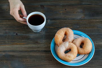 woman drinks coffee with donuts