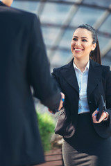 Business colleagues shaking hands outside © Mediteraneo