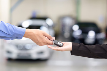 Young business women giving a key car in font of car.