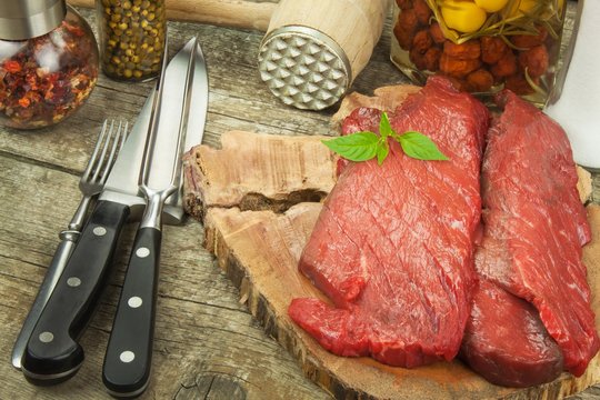 Preparing for grilling. Raw beef on a wooden board. Homework steak.