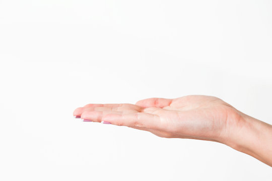 Close up of one female caucasian hand isolated on white background. Anonymous young woman holds palm as if showing something virtual and invisible on it. Horizontal color photo with copyspace.
