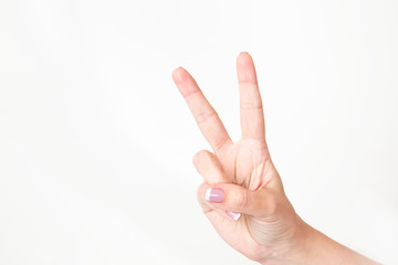 Closeup of caucasian female caucasian hand showing victory sign  isolated on white background....