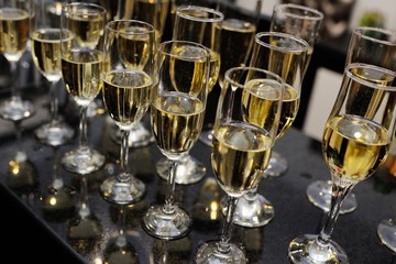 many glasses of champagne close-up against the dark wallpaper