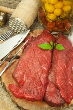 Preparing for grilling. Raw beef on a wooden board. Homework steak.
