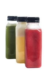 Fresh vegetable detox juice on plastic bottle over a white background