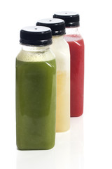 Fresh vegetable detox juice on plastic bottle over a white background