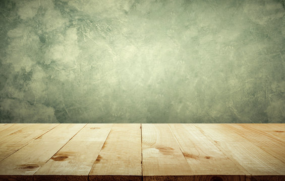 Wood table top with vintage grunge cement wall background copy space ready for your product design.