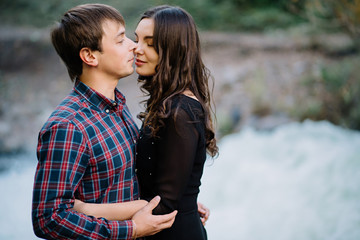 Fototapeta premium pair of beautiful brunette with a guy hugging on the nature